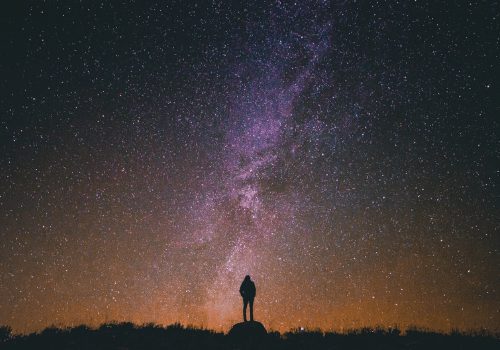 A picture of a person standing against a backdrop of stars