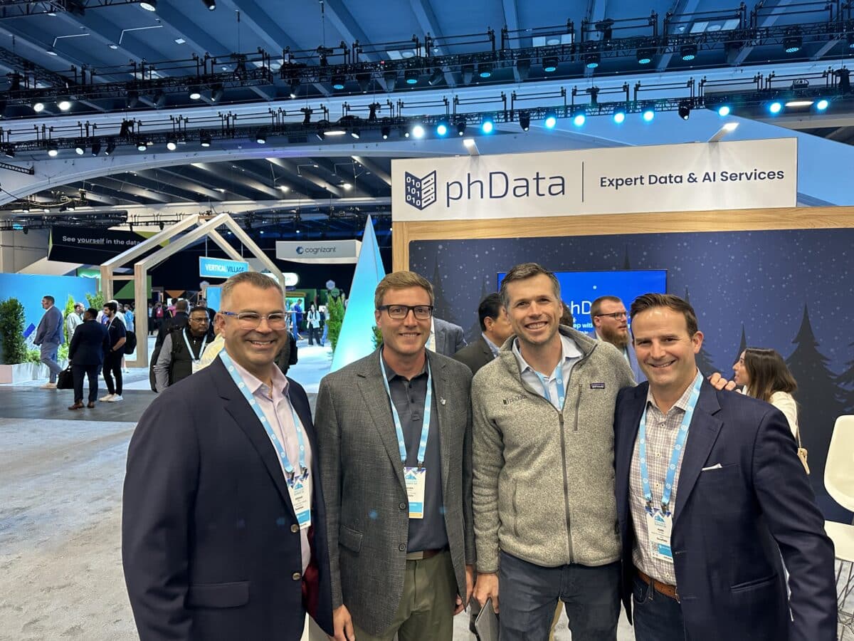 A picture of leaders from phData and Snowflake posing in front of phData's booth at Snowflake Summit 2024